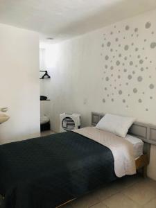 sypialnia z czarnym łóżkiem i ścianą z kropkami w obiekcie Casa Tanah w mieście Guadalajara
