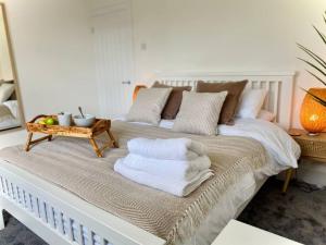 Una cama blanca con toallas en una habitación en Tranquil Bridge Escape en Canterbury
