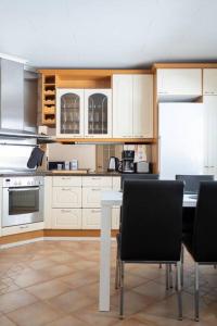 a kitchen with white cabinets and a table and chairs at Spacious house near santapark in Rovaniemi