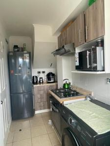 a kitchen with a stainless steel refrigerator and a stove at Casa condominio para 3 personas in Angol