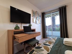 a bedroom with a desk with a laptop and a television at LE CHESTER Appartement 3 pièces Cannes proche Croisette bord de mer in Cannes