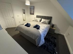 a bedroom with a bed with two blue stuffed animals on it at Modern TownHouse - 3 bed 2.5 bath 2 Private Gated Parking in Wellingborough