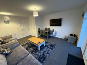sala de estar con sofá y mesa en Modern TownHouse - 3 bed 2.5 bath 2 Private Gated Parking en Wellingborough