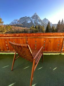 a bench sitting on top of a fence with mountains at Chalet im Rad - Wanderparadis Tiroler Zugspitze Arena in Ehrwald