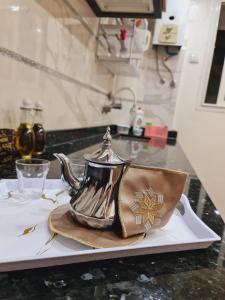 eine silberne Teekanne auf einem Teller mit einer Handtasche in der Unterkunft Apprtemment Sala Al Jadida in Oulad Yakoub