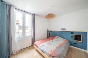 ein Schlafzimmer mit einem Bett und einem großen Fenster in der Unterkunft Maison rénové proche Paris 15. in Malakoff