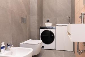 y baño con aseo y lavadora. en Exclusive Guest House - Fiera Milano Rho, en Rho