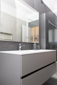 y baño con lavabo blanco y espejo. en Exclusive Guest House - Fiera Milano Rho, en Rho