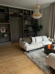 uma sala de estar com um sofá branco e um lustre em Pastors Prästgården em Norberg