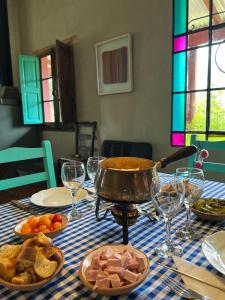 Casa de Campo La Colorada في لاس فلوريس: طاولة مع أطباق من الطعام وكؤوس النبيذ