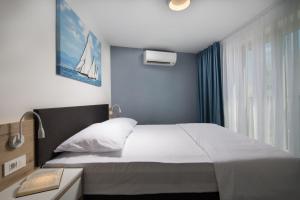 a bedroom with a large bed and a window at LUX VISTA Suite in Umag +19 photos