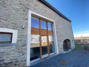 a brick building with a large glass window at Gîte Origami in Limerlé