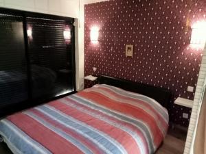 een slaapkamer met een bed met rode en blauwe strepen bij l'arche de noé 