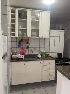 eine Küche mit weißen Schränken und einer Arbeitsplatte in der Unterkunft Apartamento com Vista para o Mar in Conceição da Barra