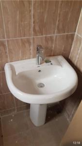 a white sink in a tiled bathroom at Annex House For Rent in Manjai Kunda