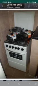 a stove with pots and pans on top of it at Annex House For Rent in Manjai Kunda