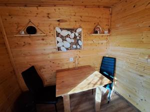 a wooden room with a wooden table and two chairs at Lélek lak faház in Debrecen