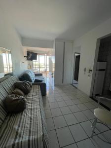 ein Wohnzimmer mit einem Sofa und einem TV in der Unterkunft Apartamento com Vista para o Mar in Conceição da Barra