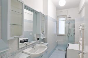 a white bathroom with a sink and a mirror at DANTE SUITE in Como