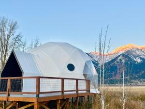 a dome house on a wooden platform with mountains in the background at Tammah Jackson Hole in Wilson