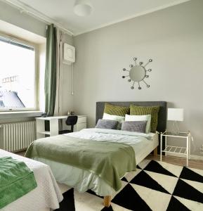 sypialnia z łóżkiem i zegarem słonecznym na ścianie w obiekcie Chic Urban Oasis at Helsinki Activity Center w Helsinkach