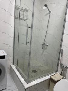 eine Dusche mit Glastür im Bad in der Unterkunft 4YOU апартаменты in Almaty