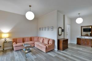 uma sala de estar com um sofá rosa e uma televisão em DANTE SUITE em Como