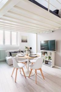 una sala de estar blanca con mesa y sillas en Briano's House (Navigli-Bocconi-Fondazione Prada), en Milán