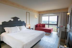 1 dormitorio con 1 cama grande y 1 silla roja en Spa do Vinho Condomínio Vitivinícola, en Bento Gonçalves