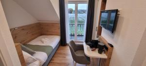 a small room with a bed and a television at Vorgebirgsblick Gästezimmer mit Self-Check-in unter neuer Verwaltung in Bornheim