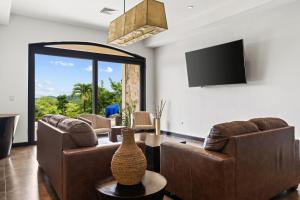 a living room with two couches and a tv at Villa Buena Onda All Inclusive in Coco