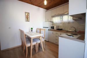 a kitchen with a table and chairs in a kitchen at Emblematic House 3 in Gjirokastër