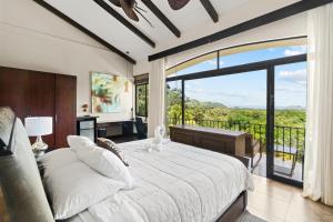 een slaapkamer met een groot bed en een groot raam bij Villa Buena Onda All Inclusive in Coco