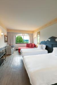 a row of four beds in a hotel room at Spa do Vinho Condomínio Vitivinícola in Bento Gonçalves