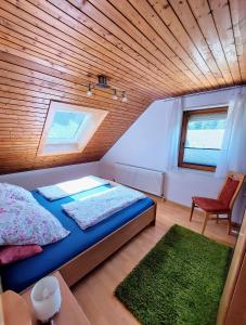 a bedroom with a bed and a window and a chair at Ferienwohnung Siggi in Hardt