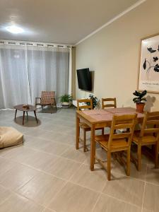a living room with a table and chairs and a tv at SnappyB Living Spaces in Alexandroupoli