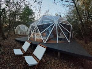 tenda e sedie su un tavolo nel bosco di Lélek Lak Dome a Debrecen