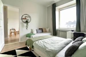 1 dormitorio con 2 camas y ventana en Chic Urban Oasis at Helsinki Activity Center, en Helsinki