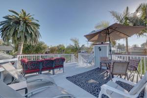 a patio with chairs and tables and an umbrella at Pelican Cove Inn in Carlsbad