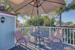 a table and chairs with an umbrella on a porch at Pelican Cove Inn in Carlsbad