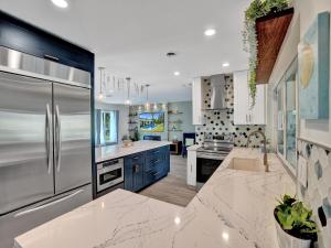 a kitchen with stainless steel appliances and blue cabinets at Amazing 5 bed house w pool, jacuzzi and your own boat in Lighthouse Point