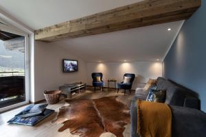 un salon avec un canapé et une grande fenêtre dans l'établissement Boutique-Ferienwohnungen Unterschwartengut inklusive Nationalpark Hohe Tauern Card, à Niedernsill
