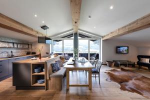 a kitchen and living room with a table and chairs at Boutique-Ferienwohnungen Unterschwartengut inklusive Nationalpark Hohe Tauern Card in Niedernsill