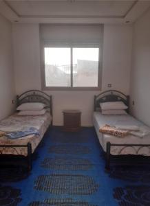 two beds in a room with a window at Your House For Family in Agadir