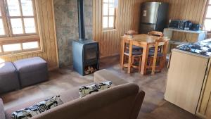 a living room with a wood stove in a kitchen at Cabañas y Restaurante Ruta 7 sur in Villa Cerro Castillo