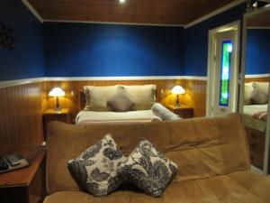 un soggiorno con divano e letto di Willowlake Cottages a Howqua