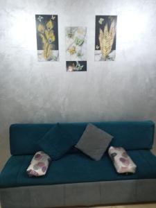 a blue couch with pillows and pictures on a wall at كمبوند سيبريا in Hurghada