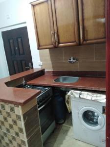 a kitchen with a sink and a washing machine at كمبوند سيبريا in Hurghada