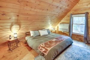 ein Schlafzimmer mit einem Bett in einem Blockhaus in der Unterkunft Waterfront Dresden Cabin with Deck and Fire Pit! 