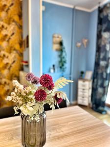wazon wypełniony kwiatami na stole w obiekcie Candy House w mieście Lido di Ostia